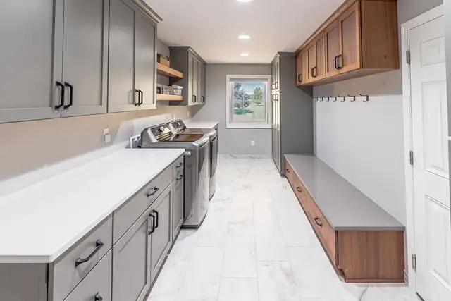 Laundry and mudroom remodel with gray and walnut cabinets, quartz folding counter, built-in bench and coat hooks
