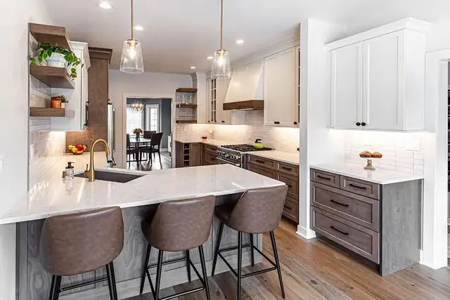 Kitchen remodel with white and stained wood cabinets, quartz peninsula, open wood shelves and glass pendants